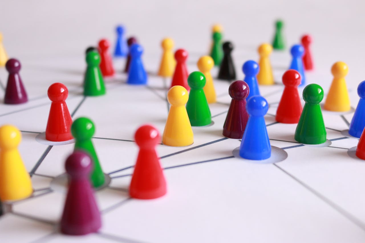 footer-cta A strategic arrangement of colorful pawns connected on a game board, symbolizing networking and teamwork.
